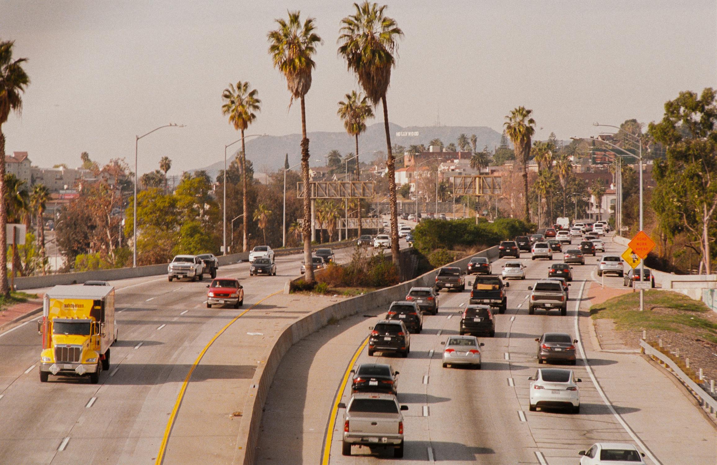 Busy Los Angeles highway with Hollywood sign visible in background