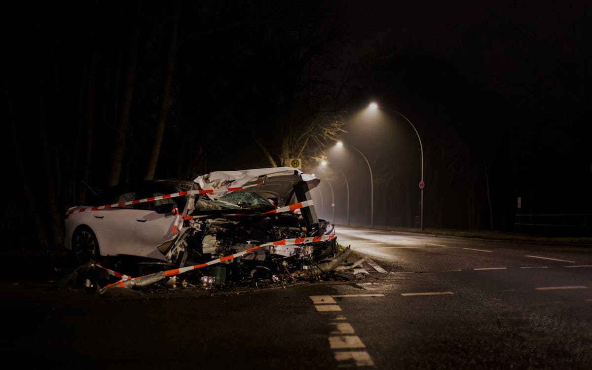 Wrecked car after a collision on a street at night, depicting hit-and-run accident aftermath